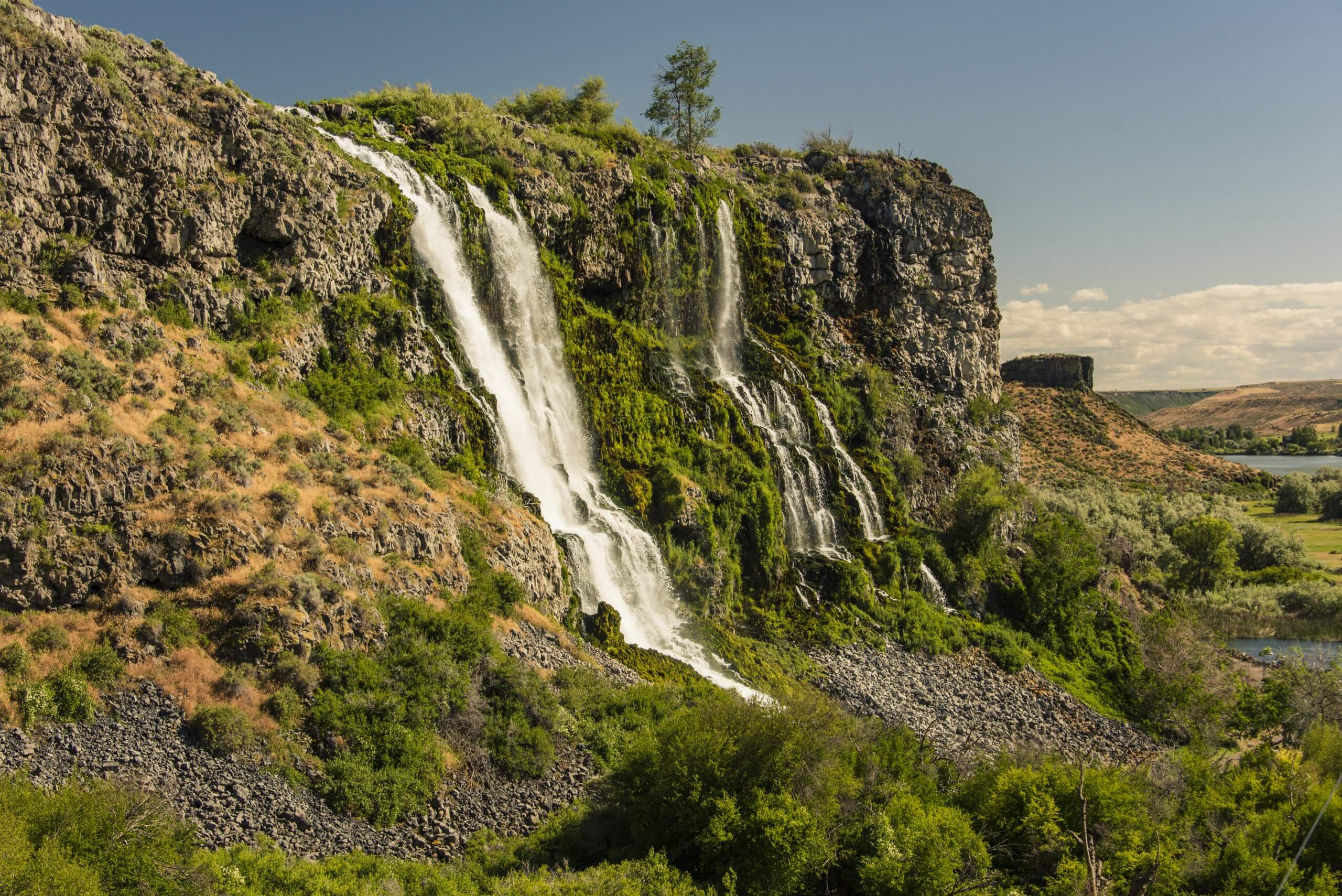 A sideview of a waterfall at Thousand Springs State Park in the summer.