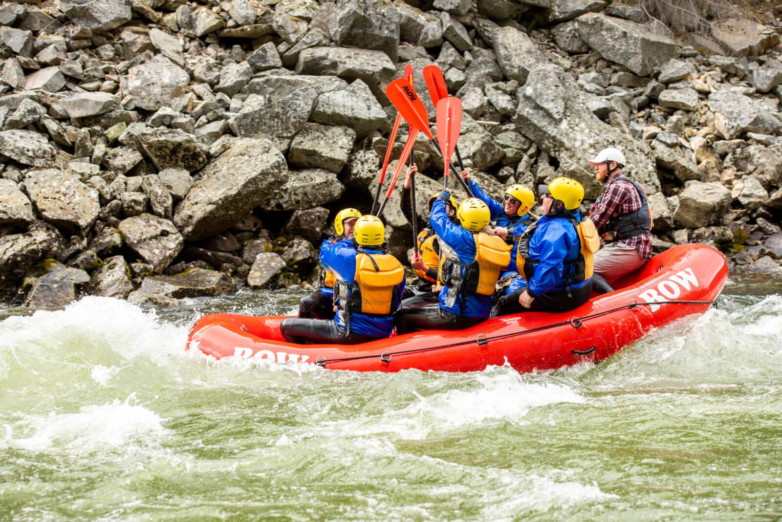 people smack their red rafting paddles together in excitement as they raft down the Lochsa River