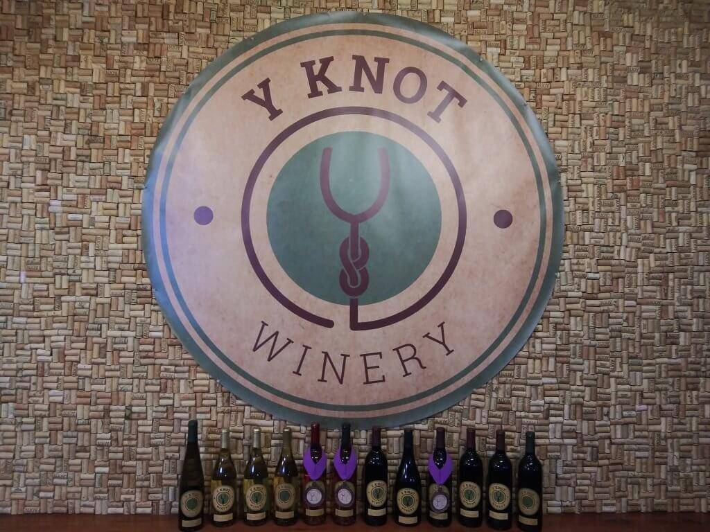 Y Knot Winery tasting room counter with award-winning wine in front.