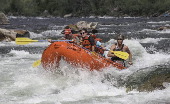 A group of people rafting down Salmon River rapids together. 