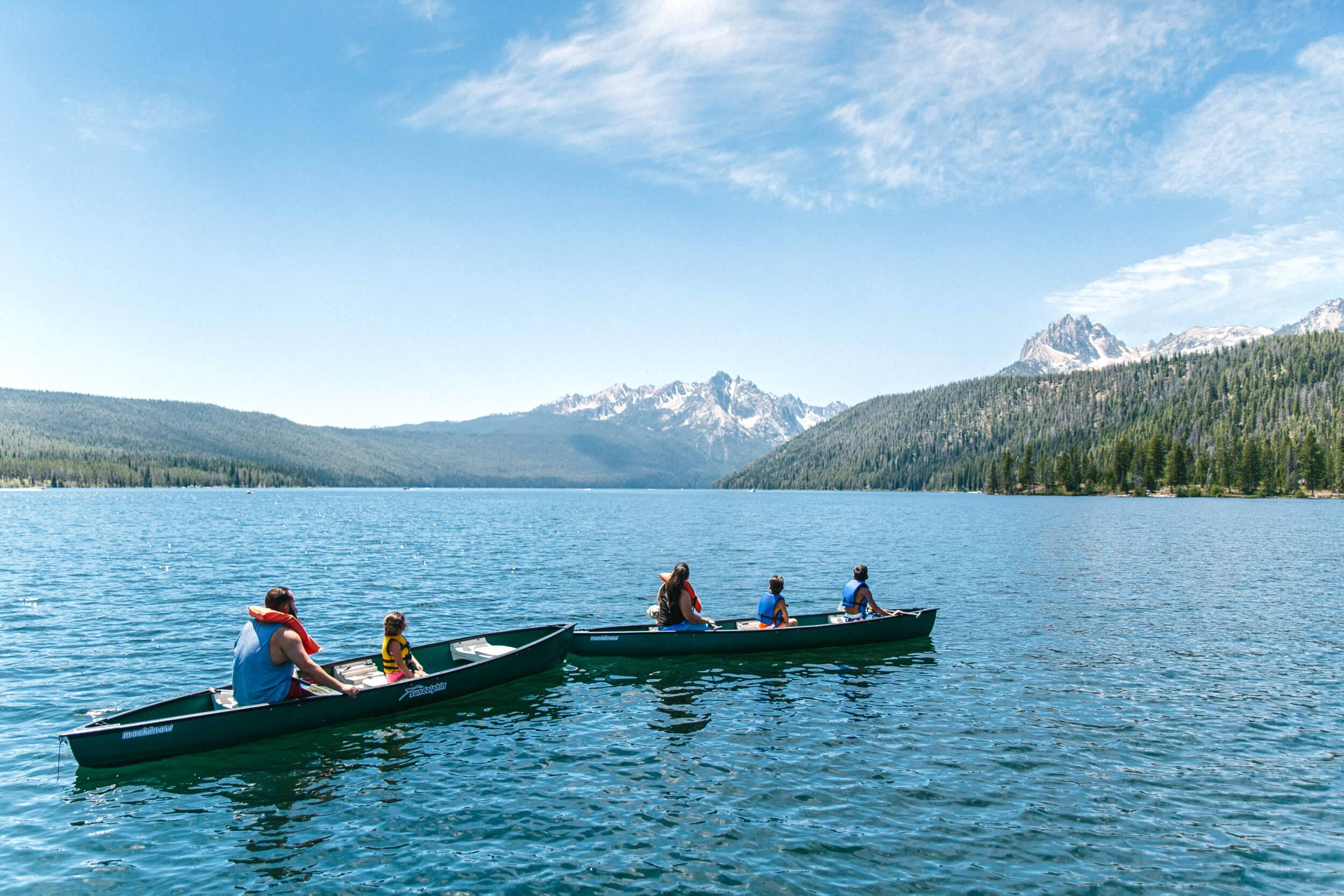 A family of five in two canoes paddle through Redfish Lake in Idaho