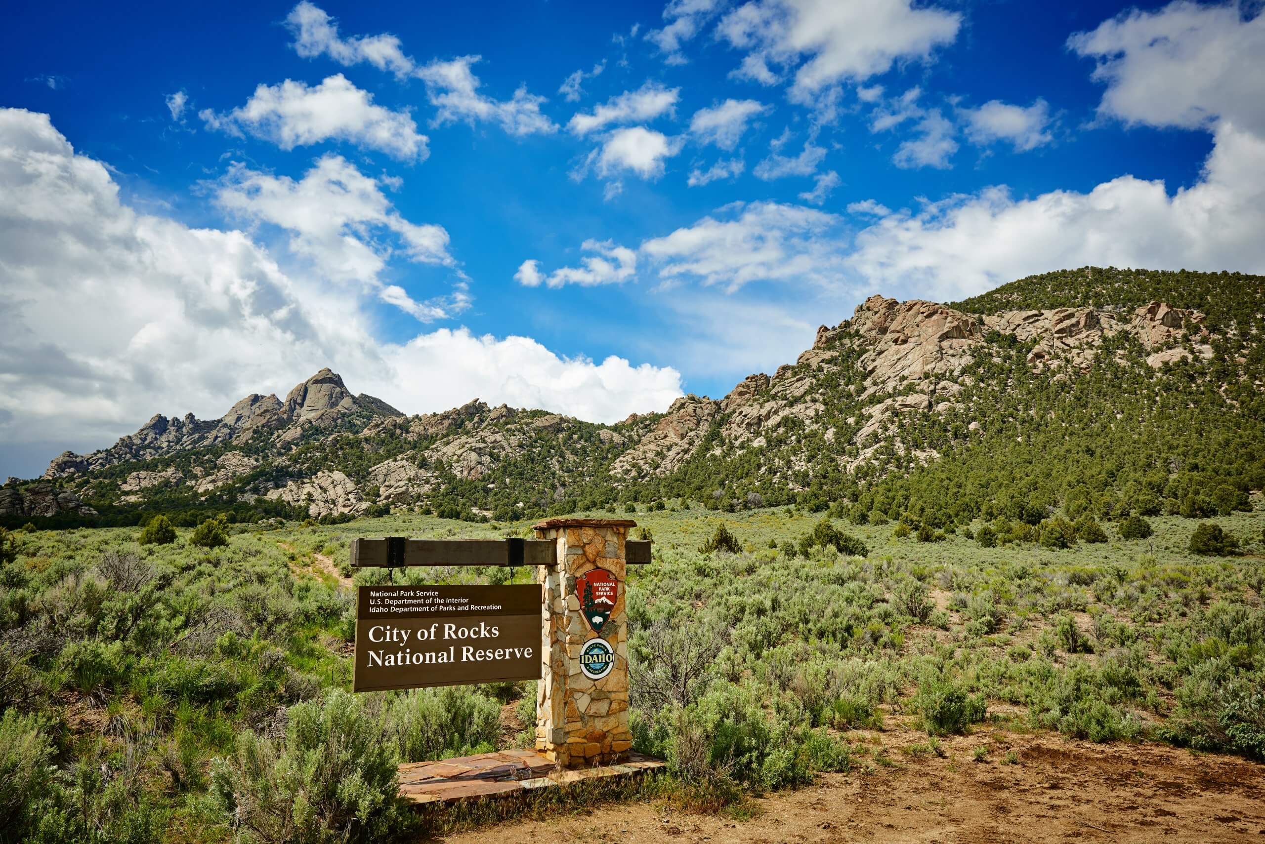 City of Rocks National Reserve signage sits in front of a mountain range.