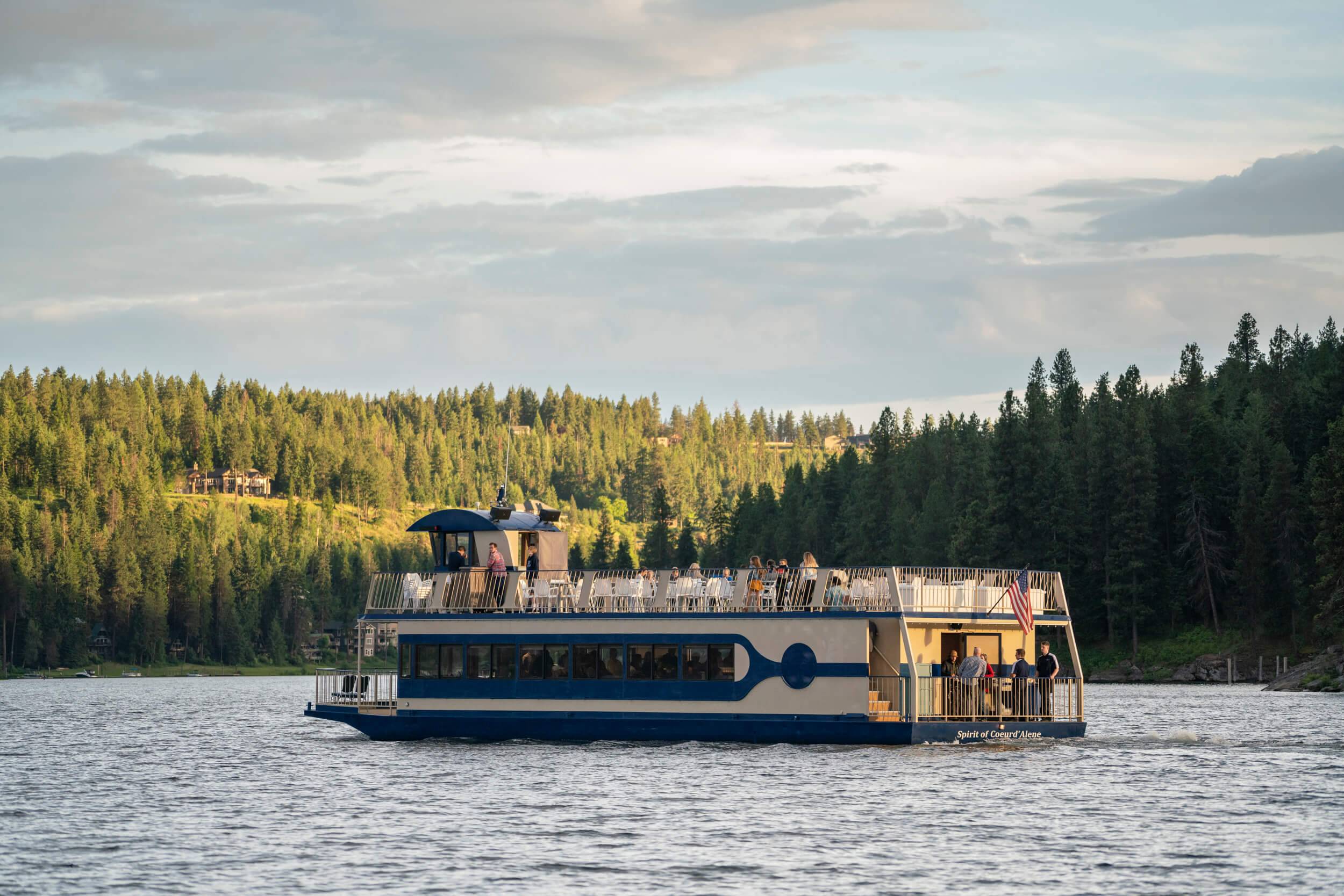 CDA Cruise ship with passengers on Lake Coeur d'Alene surrounded by trees