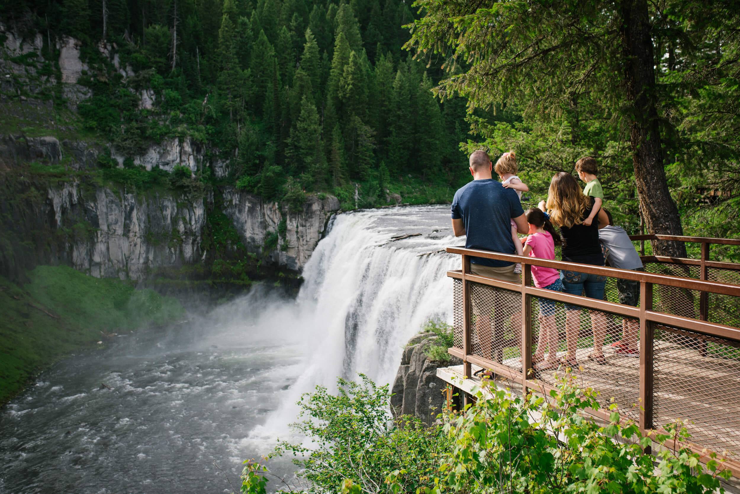 a family admiring Upper Mesa Falls from the viewing deck.