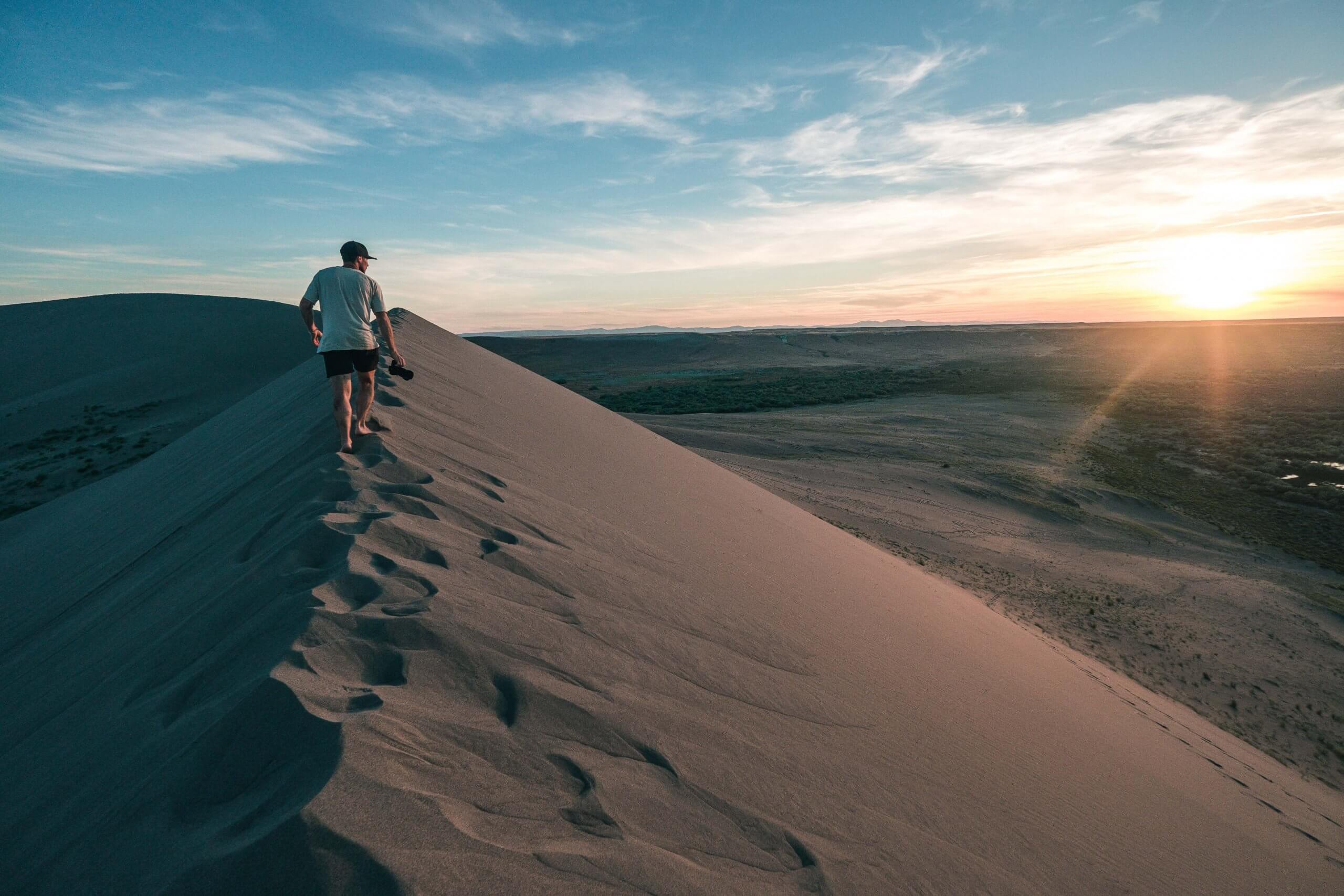 A man runs along the top of a sand dune at Bruneau Dunes State Park.