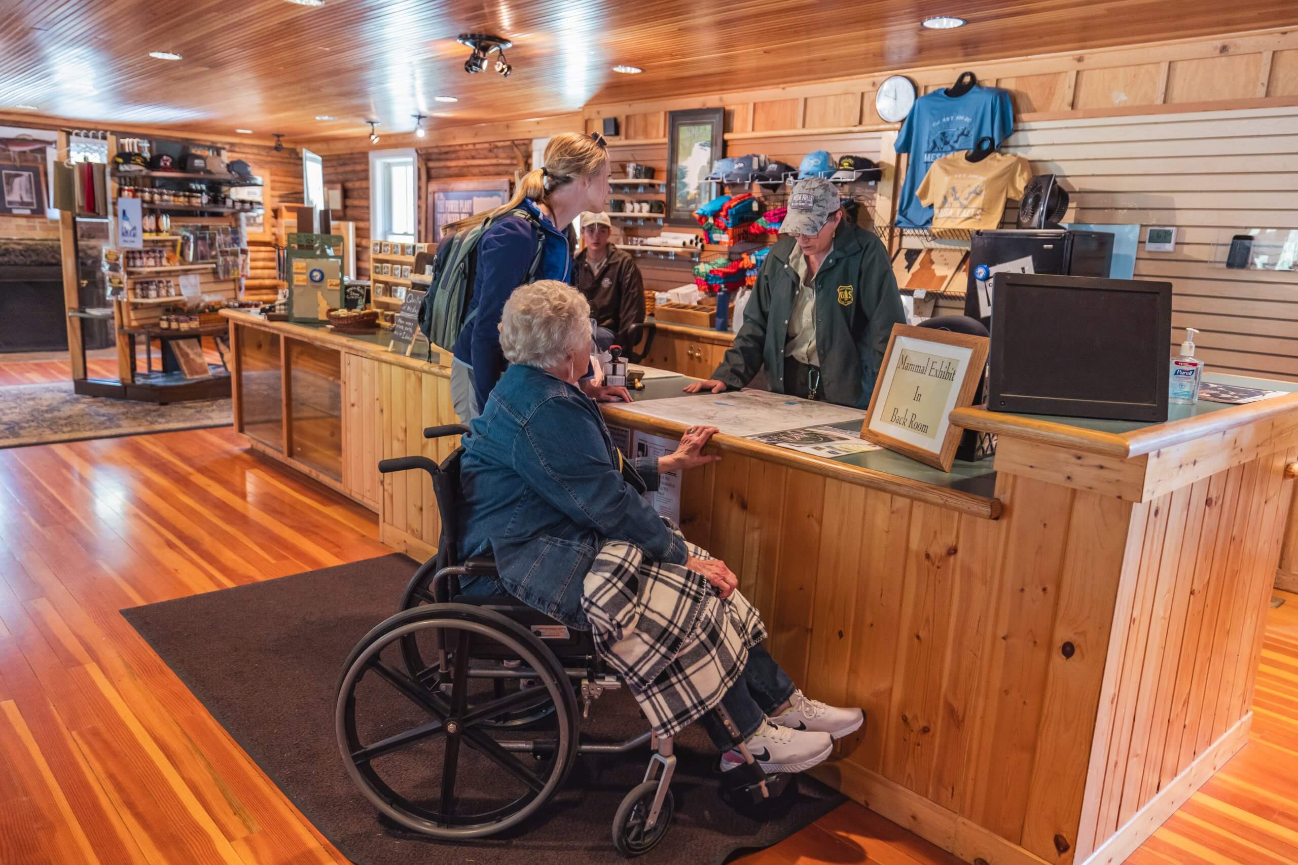 Two women talk with a park ranger inside the Mesa Falls Visitor Center.