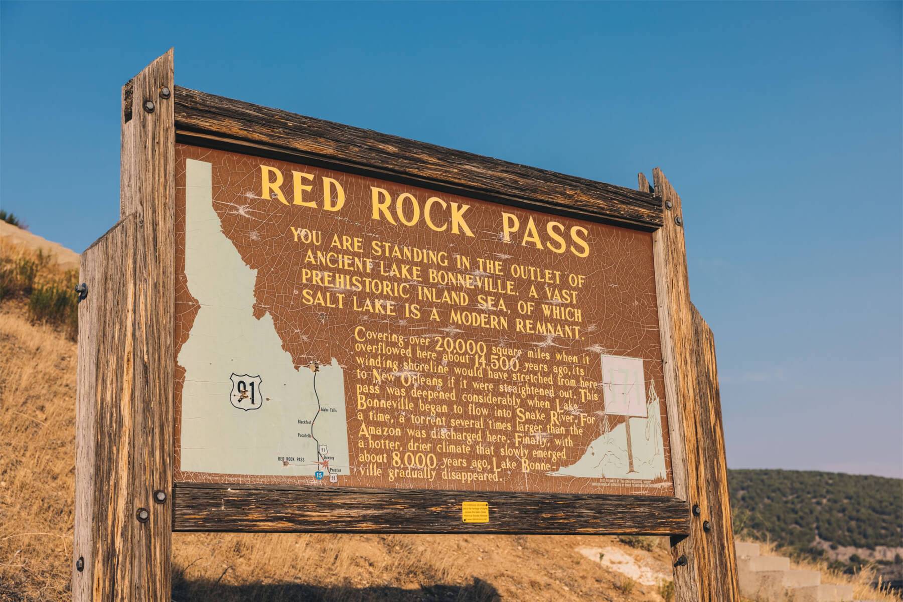 a wooden sign for Red Rock Pass, including a map of Idaho