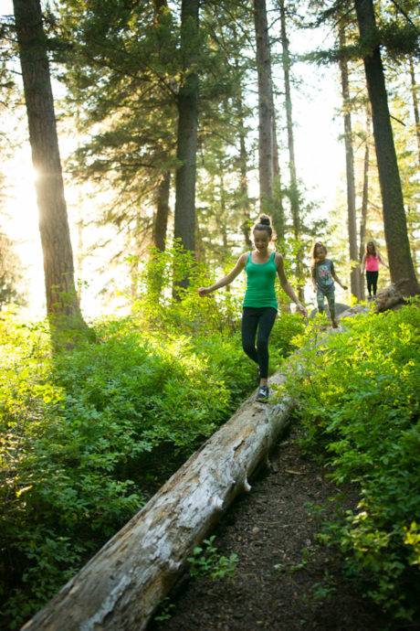 Kids walking on a log in a forest of a state park. 