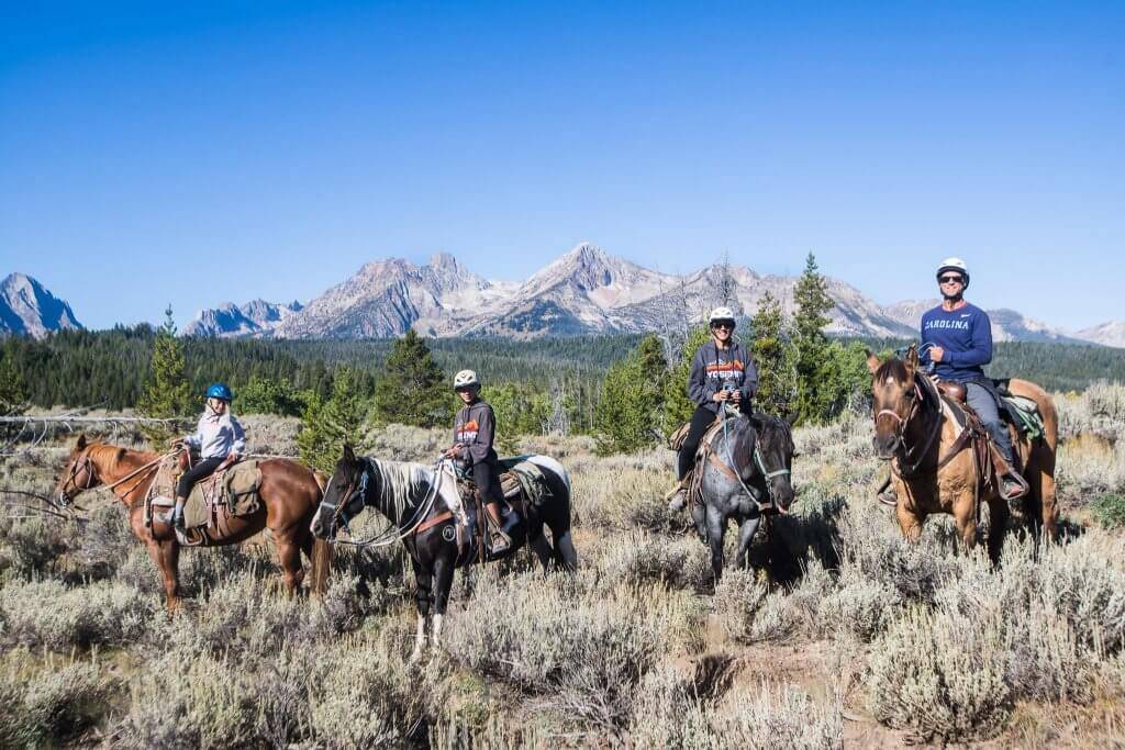 family on horseback ride in sawtooth mountains