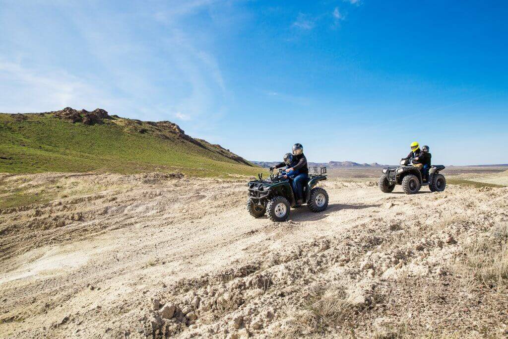 A family riding ATVs on a trail.