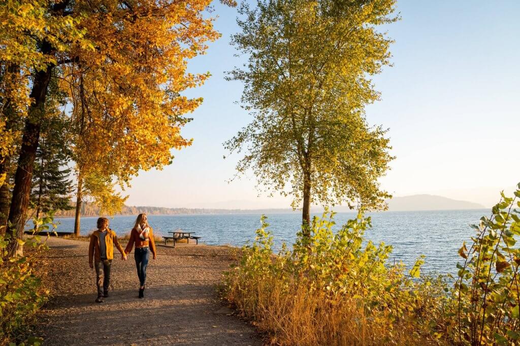 Two people walk along the Pend d'Oreille Bay Trail in Sandpoint Idaho.