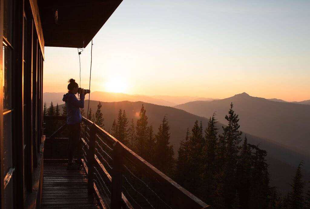 woman standing outside deck of fire lookout