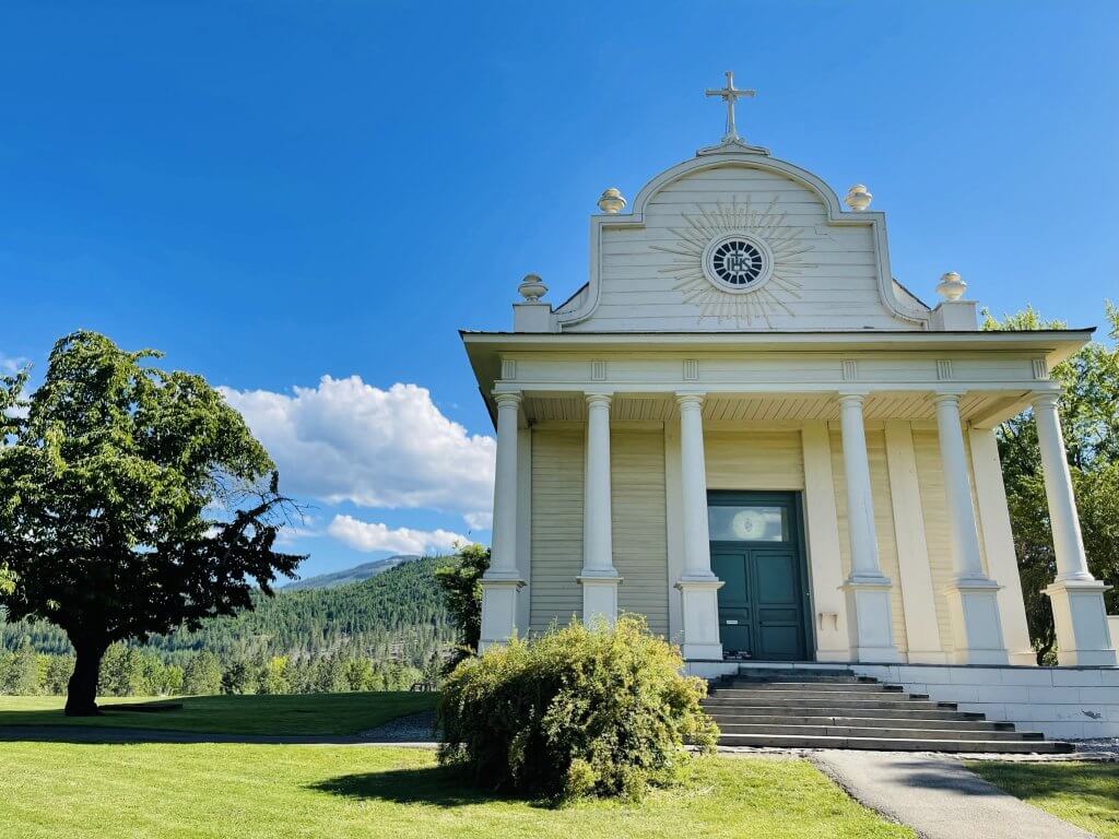 Exterior shot of white, wood Cataldo Mission at Coeur d'Alene's Old Mission State Park. 