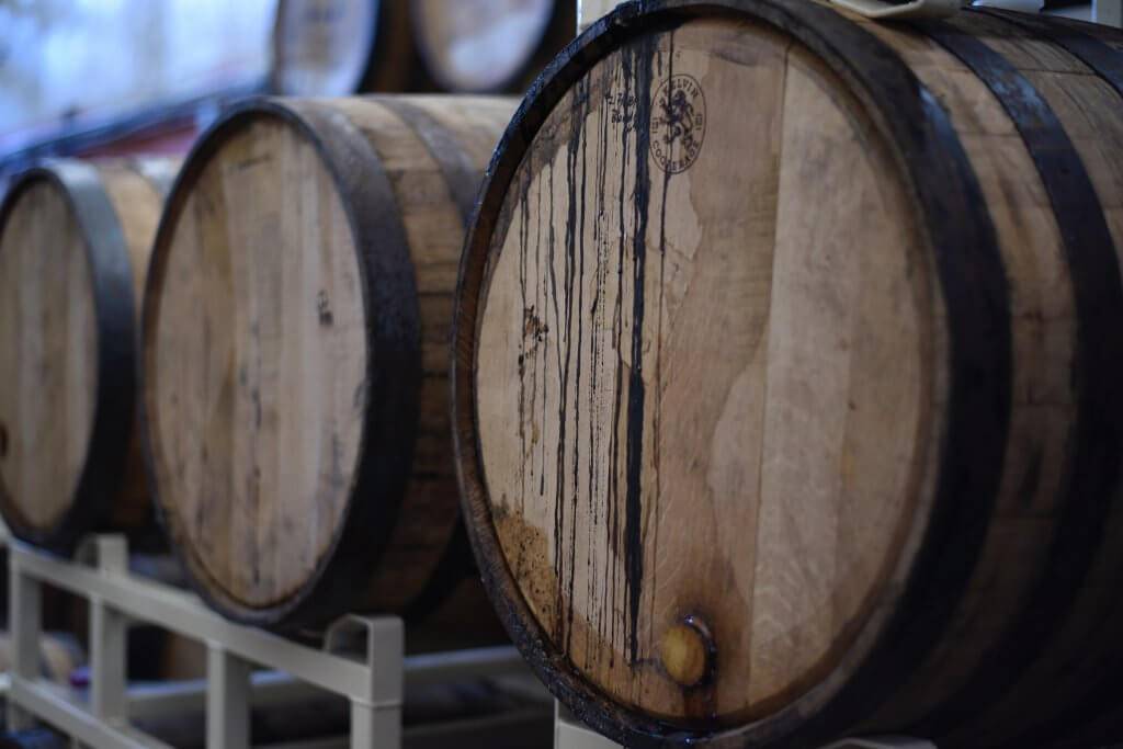 Up-close view of three distillery barrels laying on their sides.