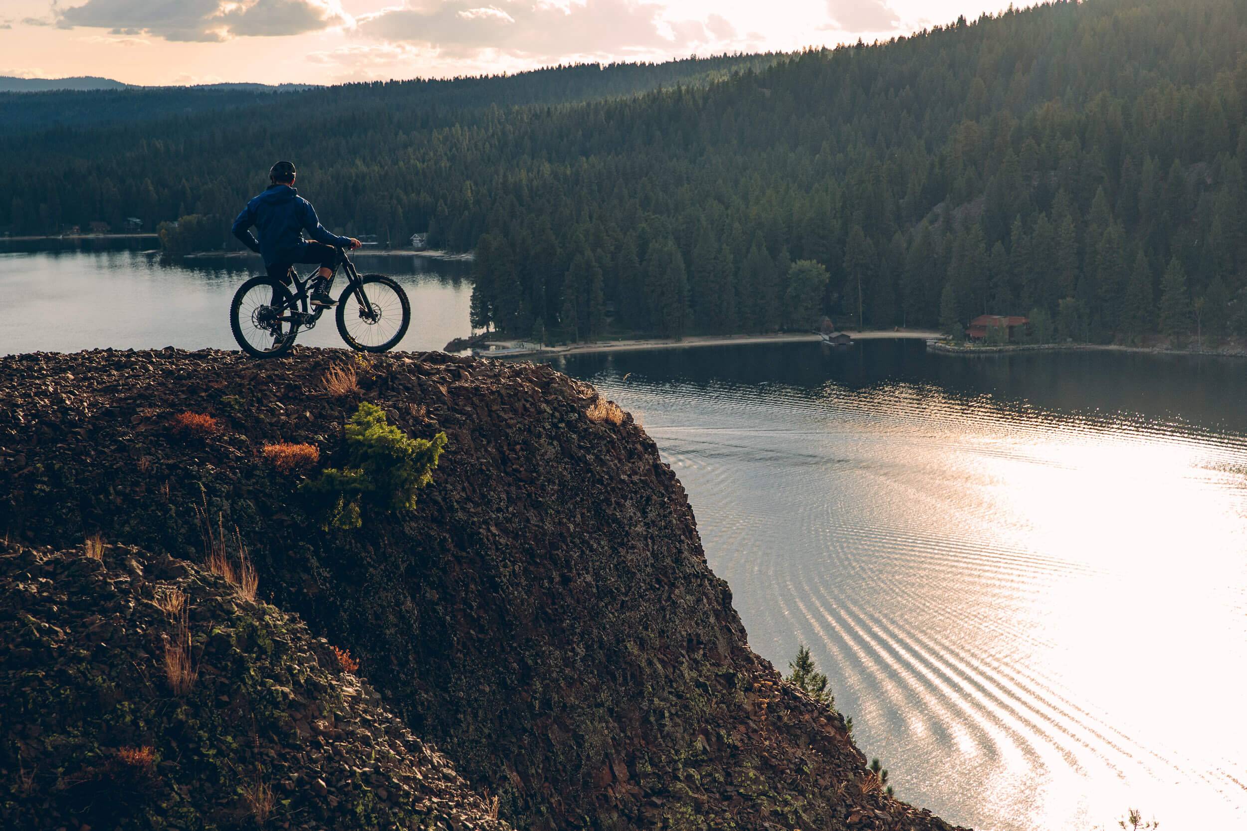 A person on a mountain bike at Osprey Point, overlooking Payette Lake at Ponderosa State Park.
