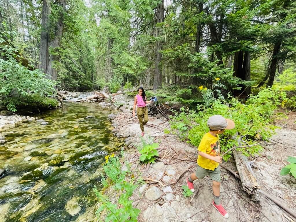 A mother and son walk along a clear mountain stream at Indian Creek Campground.
