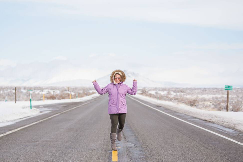 woman in snow gear on snowy road