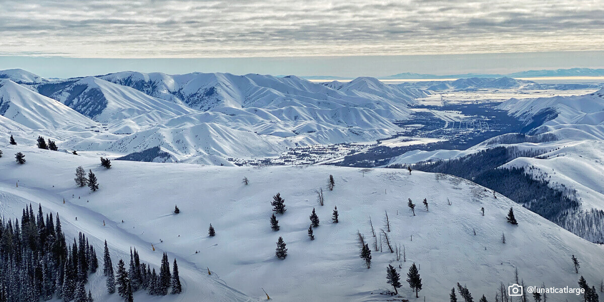 Wide angle shot of a person skiing down a run at Bald Mountain in Sun Valley.
