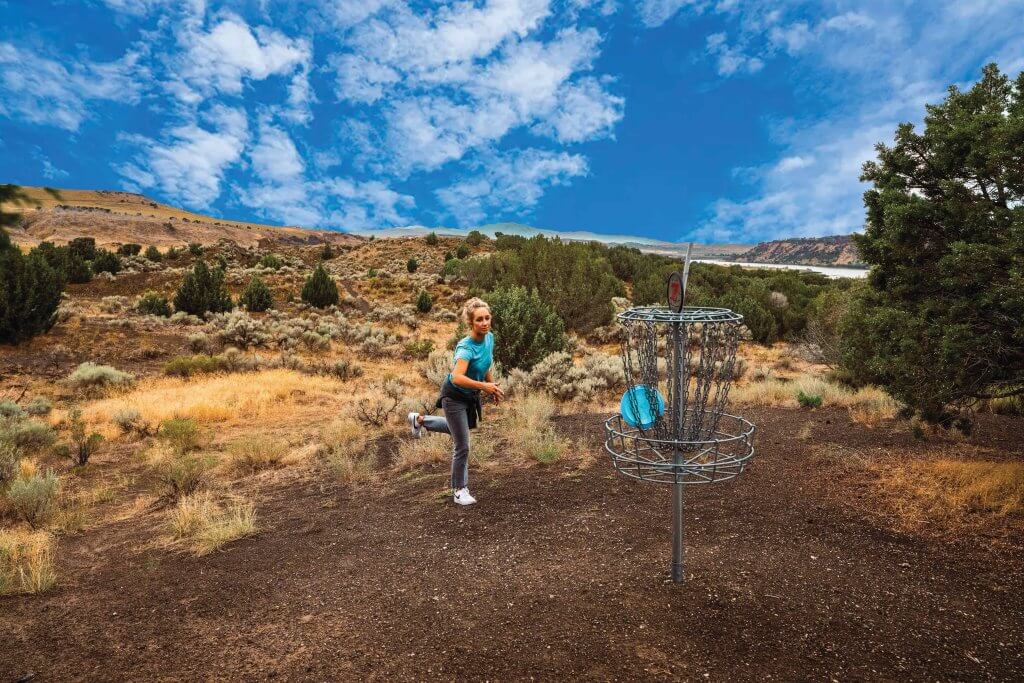 A woman playing disc golf at Massacre Rocks State Park.