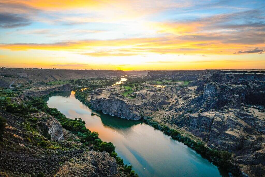 An aerial view of the sun setting over the Snake River in Snake River Canyon.
