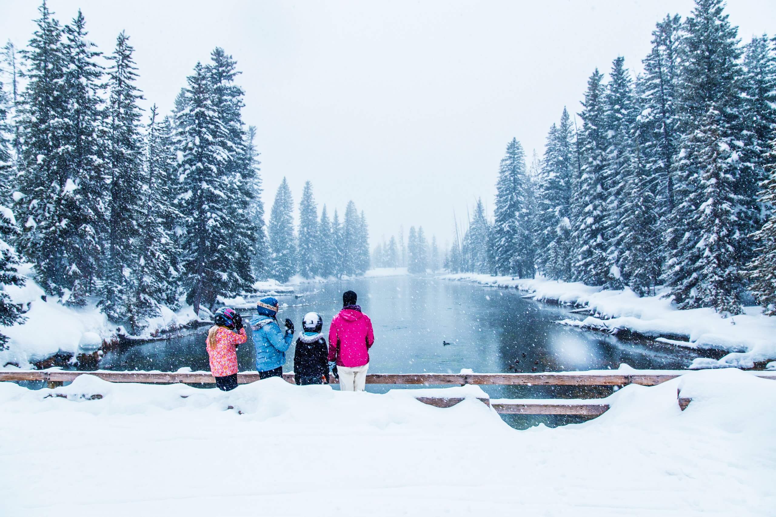 A mother and children looking out at a frozen Big Springs at Island Park, Idaho.