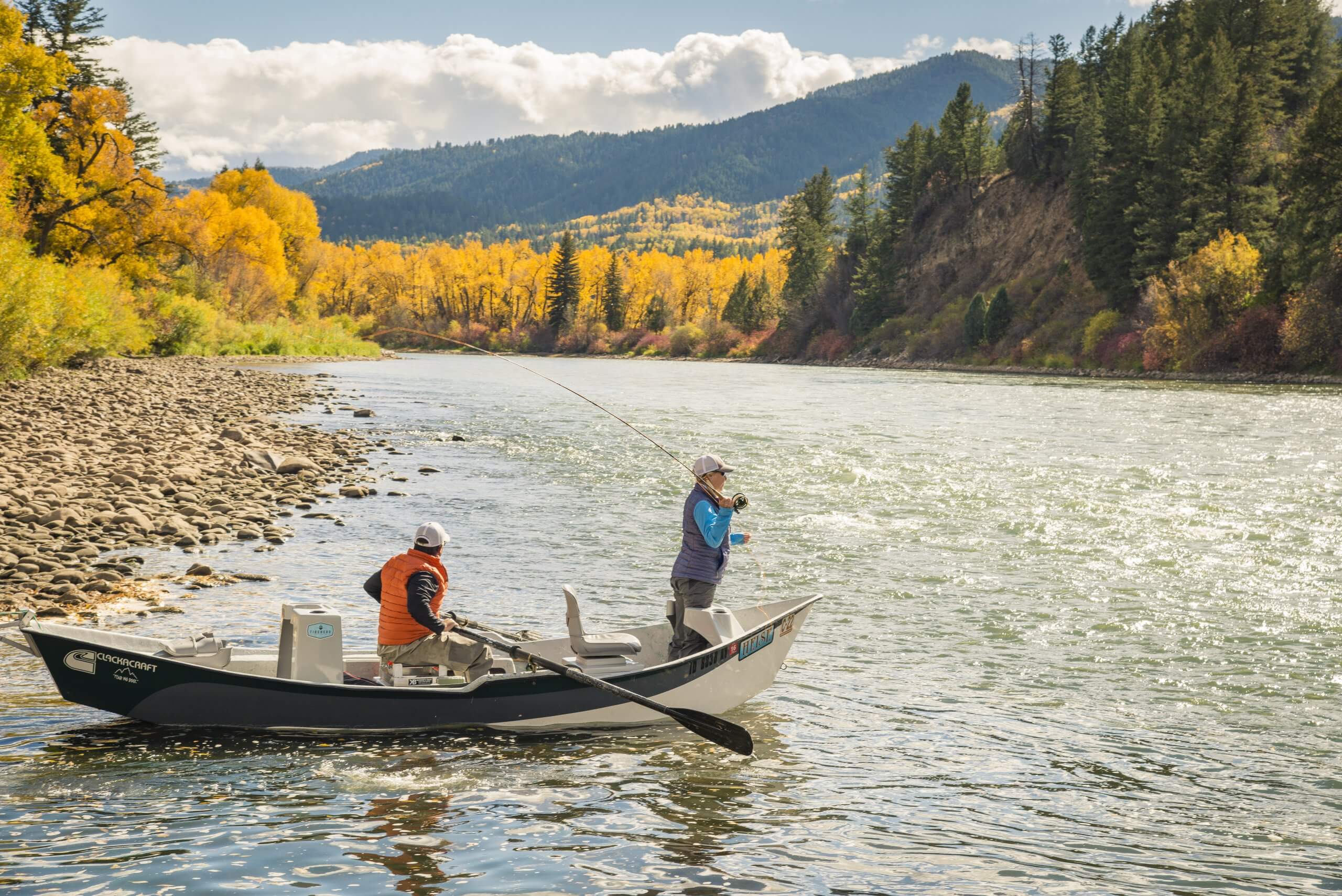 Two men fishing on the Snake River surrounded by fall colors.