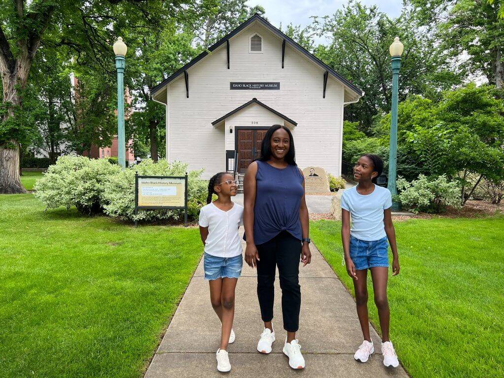 mom and two daughters walking on path in front of Idaho Black History Museum