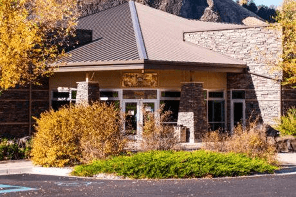 Exterior view of Hells Gate visitor center surrounded by fall trees.